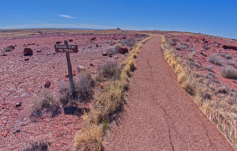 A warning sign to stay on the trail to the historic Agate House in Petrified Forest National Park, Arizona, United States of America, North America