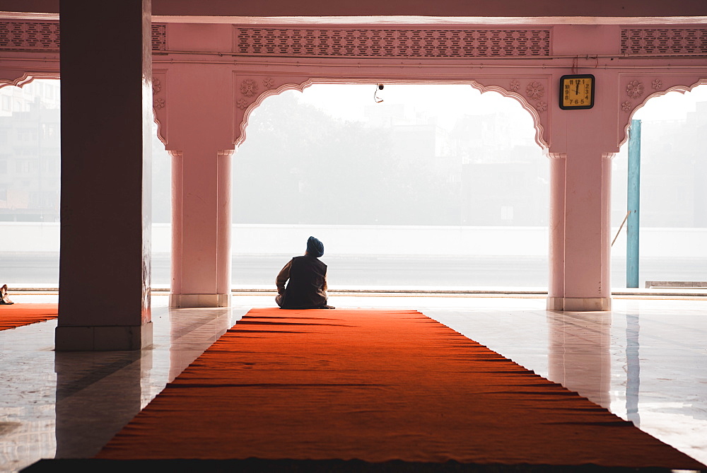 A man contemplates at Gurudwara Santokhsar Temple, Amritsar, Punjab, India, Asia