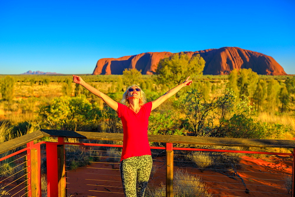 Tourist woman enjoying Uluru-Kata Tjuta National Park, UNESCO World Heritge Site, with Uluru and Kata Tjuta in the background, Northern Territory, Australia, Pacific