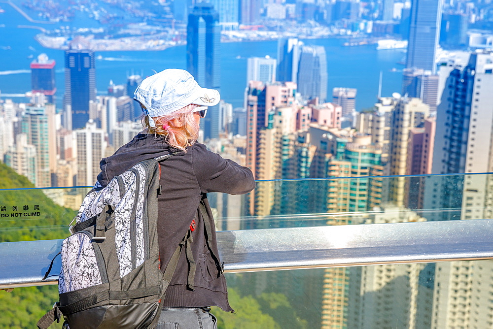 Tourist looking at the view of Victoria Harbour from Peak Tower, Hong Kong, China, Asia