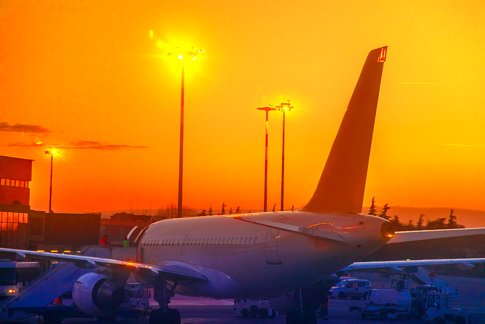 Commercial airplane parked in airport park at sunset, refuelling in taxi mode, United States of America, North America