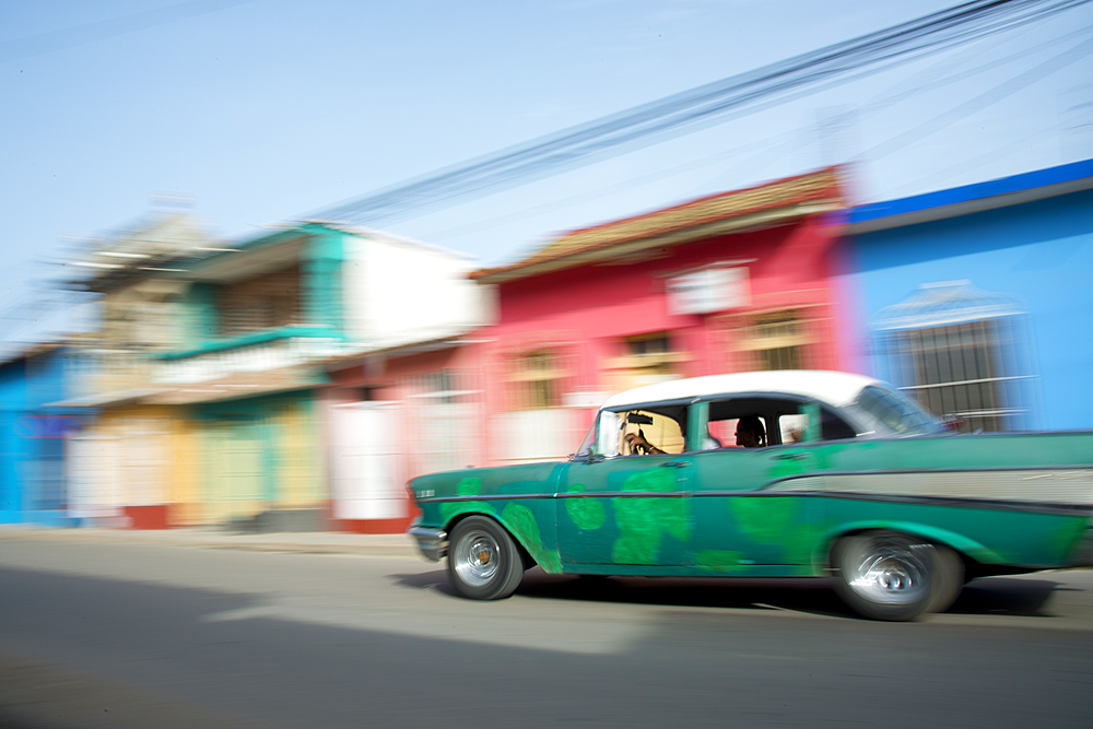 Old car blurring by on the streets of Trinidad, Cuba, West Indies, Caribbean, Central America