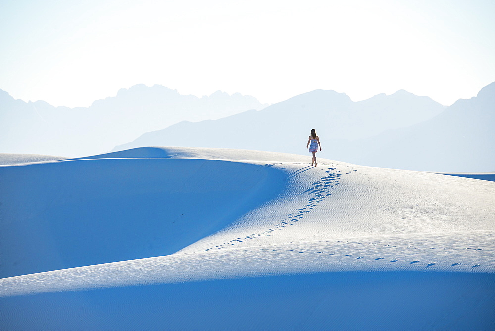 A woman walking along a dune's ridge in White Sands National Park, New Mexico, United States of America, North America