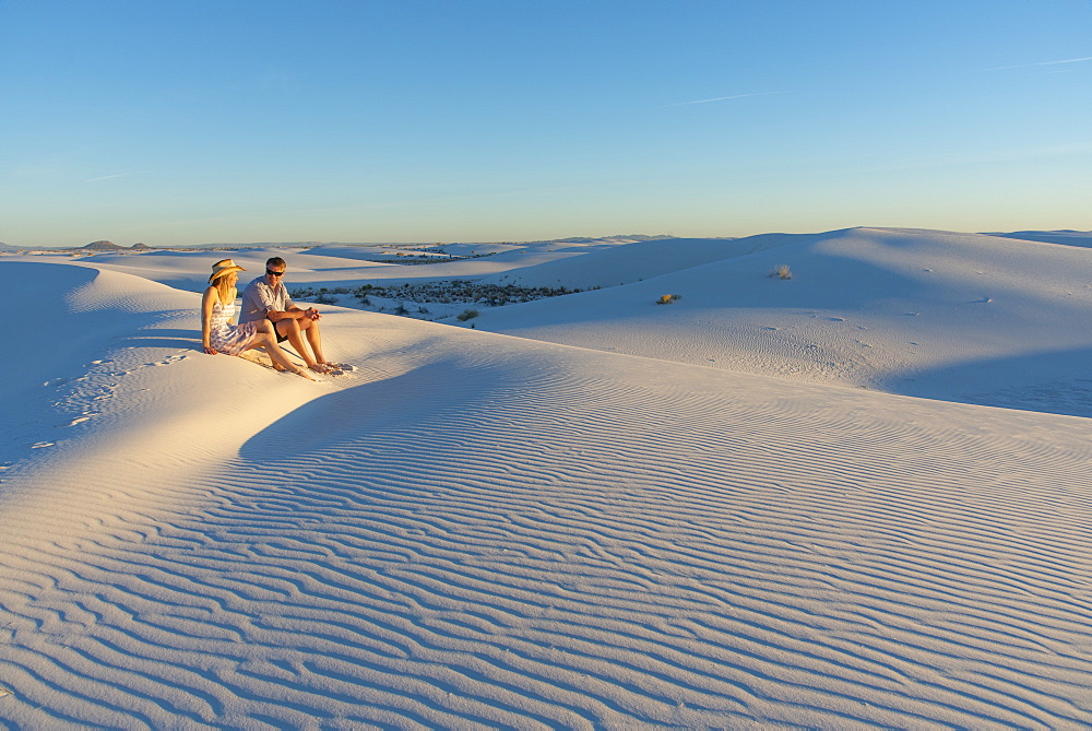 A couple enjoys White Sands National Park at sunset, New Mexico, United States of America, North America