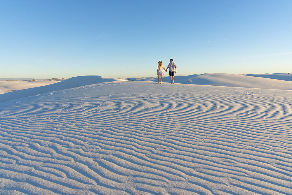 A couple enjoy White Sands National Park at sunset, New Mexico, United States of America, North America