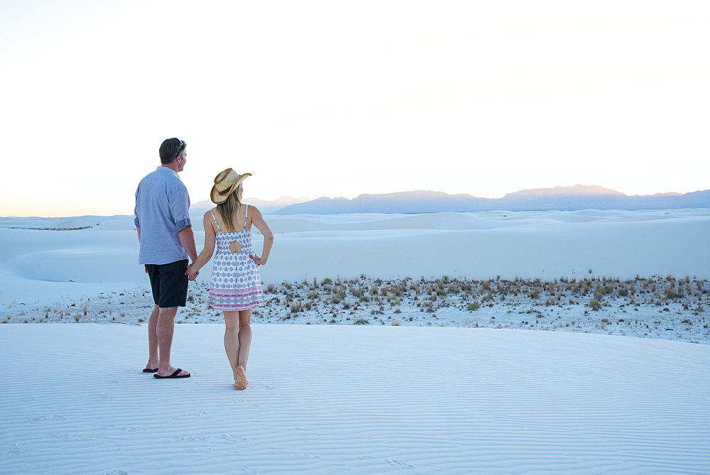 A couple enjoys White Sands National Park at sunset, New Mexico, United States of America, North America