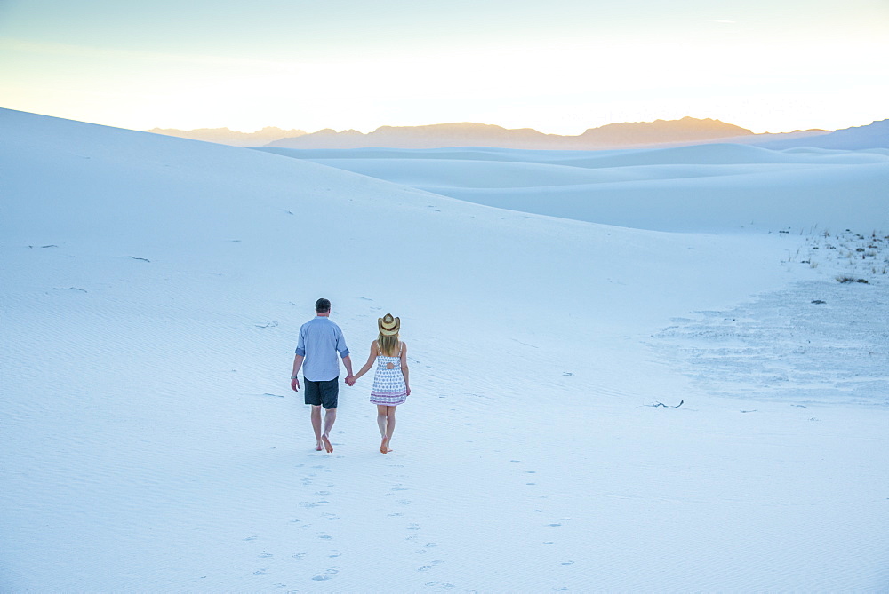 A couple enjoy White Sands National Park at sunset, New Mexico, United States of America, North America