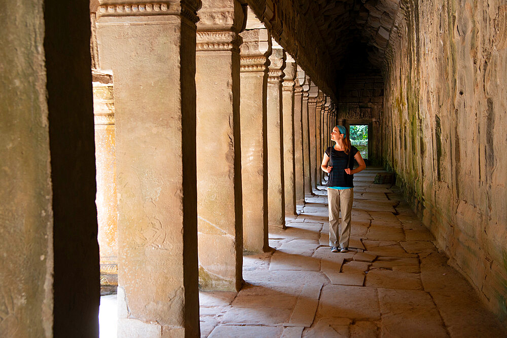 Young woman strolling through the Angkor archaeological complex, UNESCO World Heritage Site, Siem Reap, Cambodia, Indochina, Southeast Asia, Asia