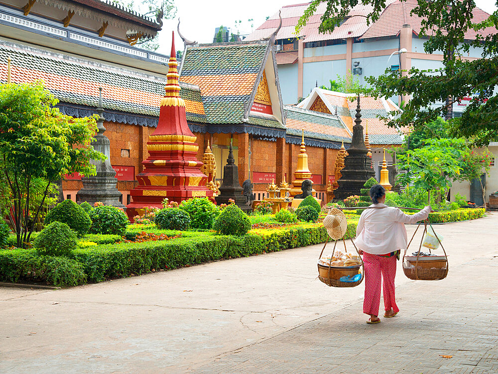 Woman carrying baskets over her shoulders outside a temple in Siem Reap, Cambodia, Indochina, Southeast Asia, Asia