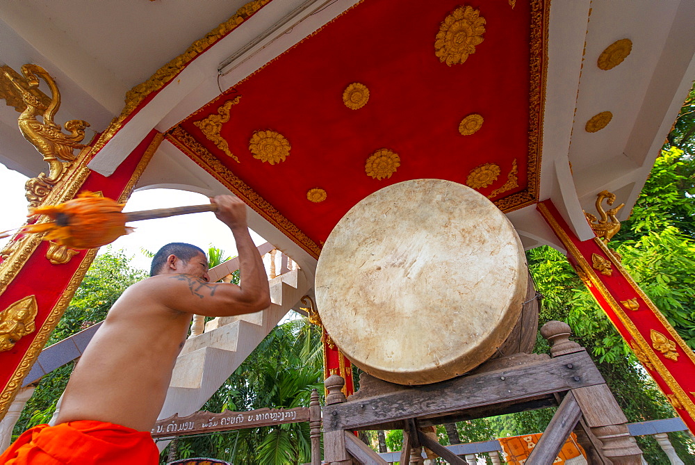 A monk sounding a gong, Vientiane, Laos, Indochina, Southeast Asia, Asia