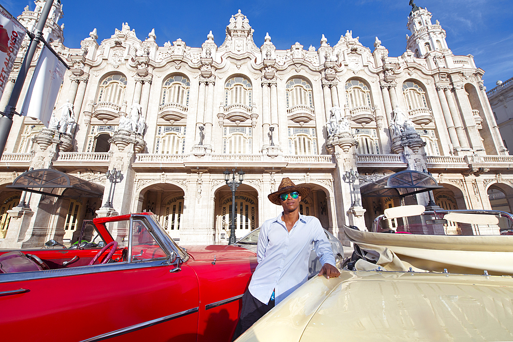 Taxi driver next to his vintage car in front of the Gran Teatro de La Habana, Havana, Cuba, West Indies, Caribbean, Central America