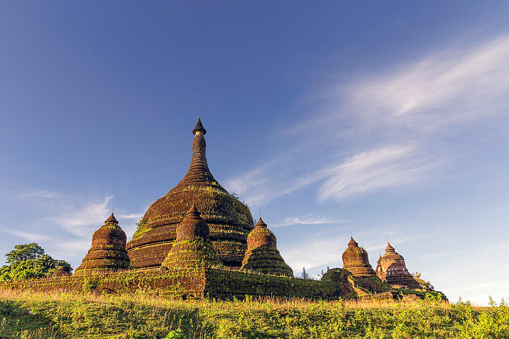 Looking up at the main stupa with satellite stupas of Andaw Thein pagoda with a few wispy clouds in a blue sky above, Mrauk U, Rakhine, Myanmar (Burma), Asia