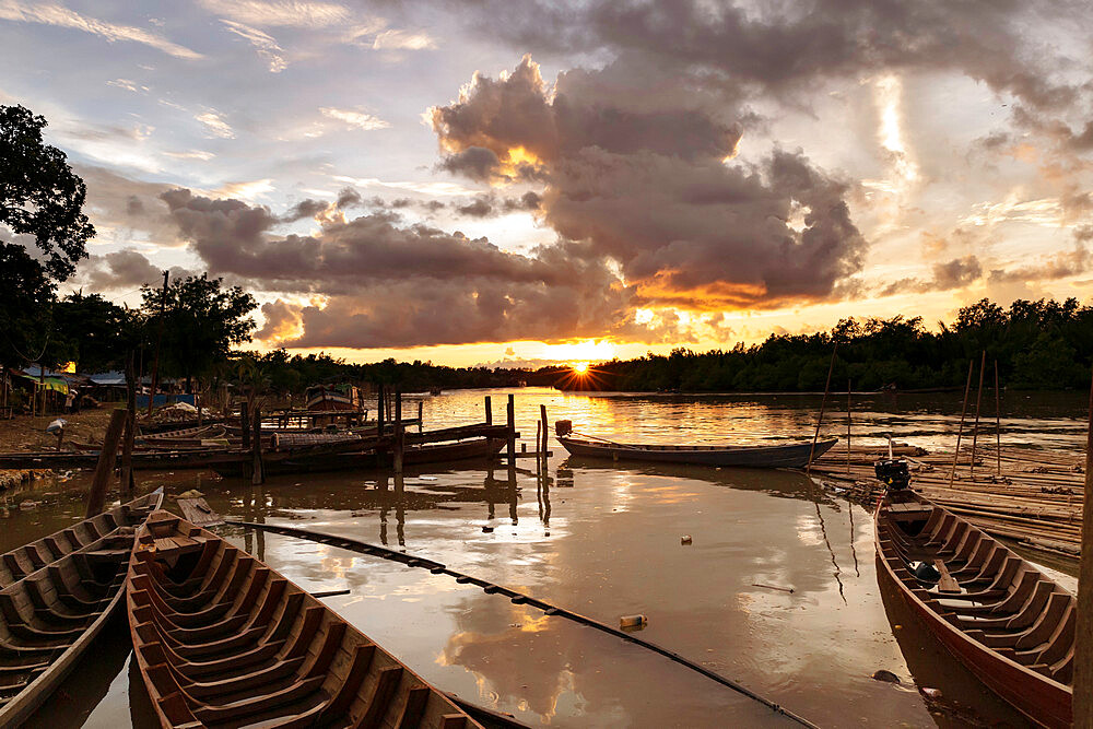 Mrauk U boat jetty at sunset showing waterlogged canoes in the foreground, Mrauk U, Rakhine, Myanmar (Burma), Asia