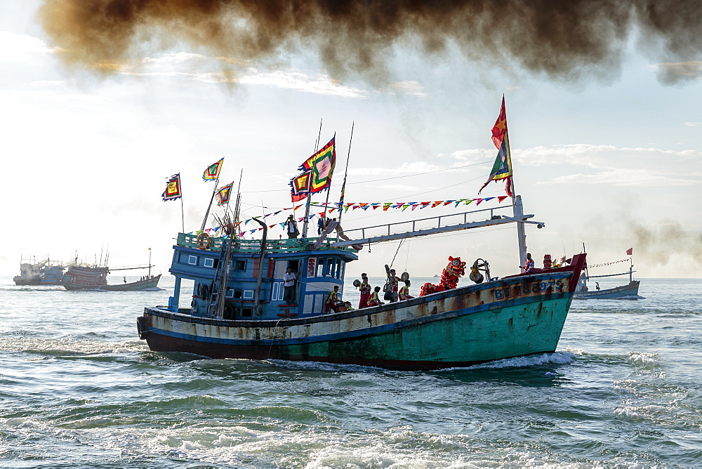 A fishing trawler at sea, taking part in the annual whale festival, with a lion dance on deck and other boats in the background, Vietnam, Indochina, Southeast Asia, Asia