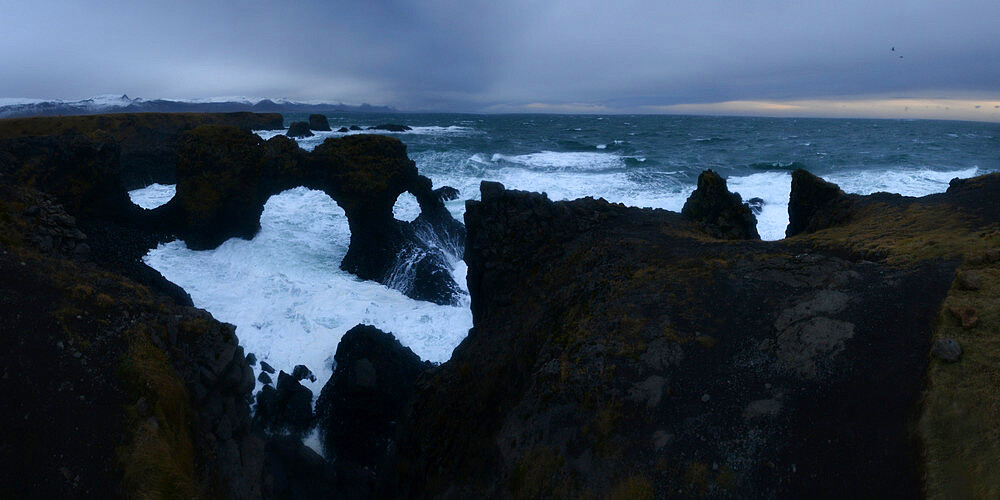 Waves crashing into lava cliffs and sea arch, Iceland, Polar Regions