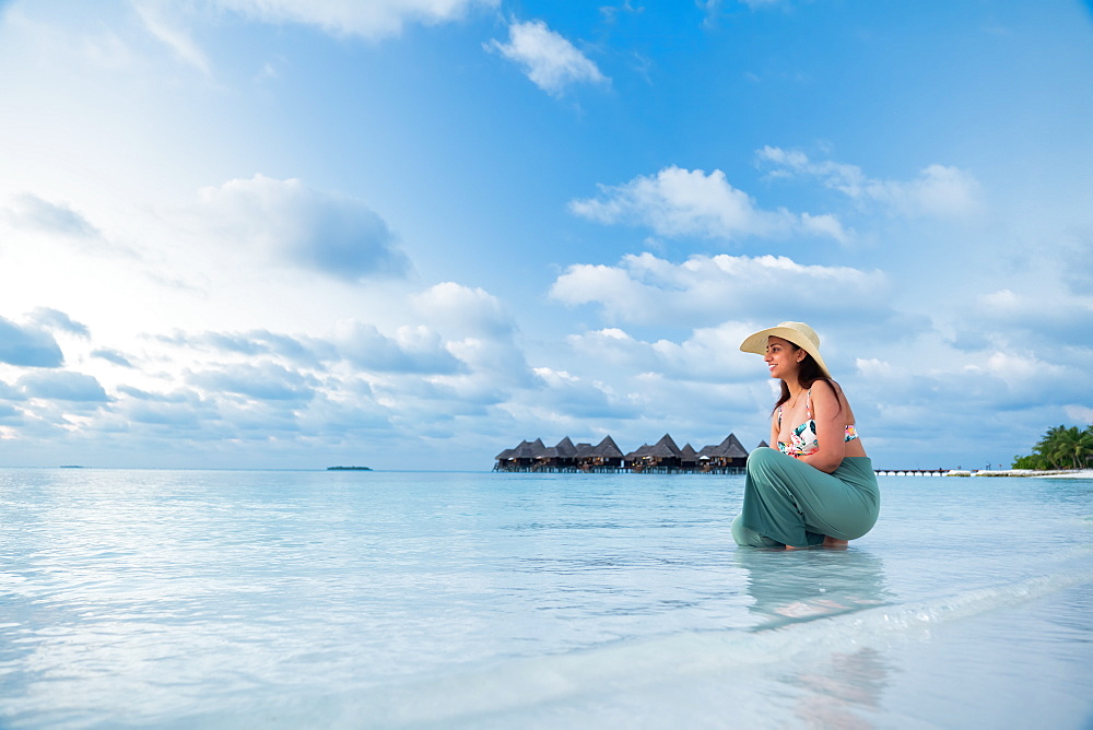 A female Indian tourist at the blue waters and white sand beach, The Maldives, Indian Ocean, Asia