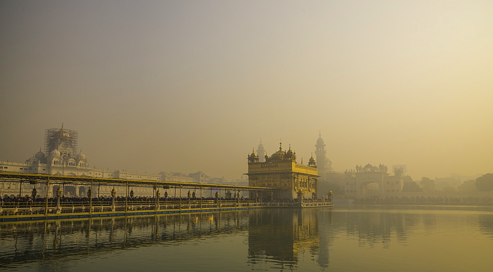 The Golden Temple at sunrise through fog, Amritsar, Punjab, India, Asia