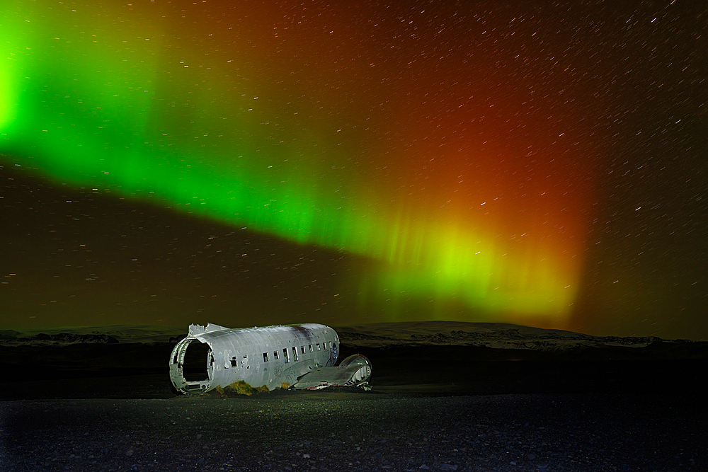 A crashed DC-3 aircraft under the Northern Lights (Aurora Borealis), Iceland, Polar Regions