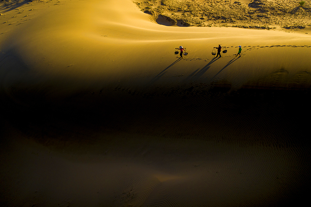 People walking home across Nam Cuong sand dunes, Ninh Thuan, Vietnam, Indochina, Southeast Asia, Asia