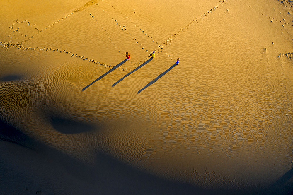 People walking home across Nam Cuong sand dunes, Ninh Thuan, Vietnam, Indochina, Southeast Asia, Asia