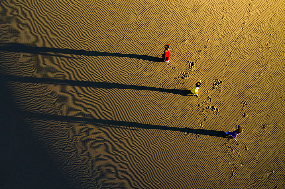 People walking home across Nam Cuong sand dunes, Ninh Thuan, Vietnam, Indochina, Southeast Asia, Asia