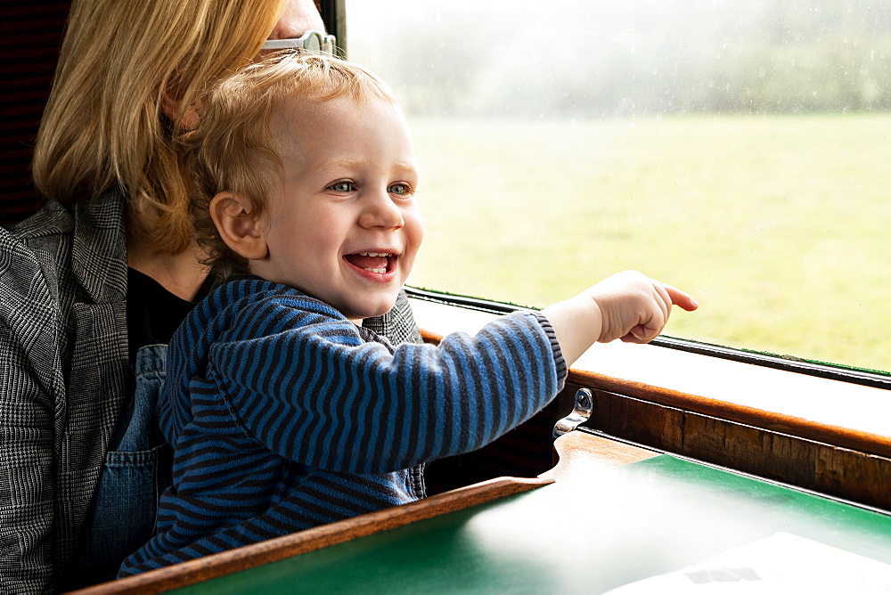 Two year old boy and Mother in old steam train carriage pointing out of window, Bluebell Railway, Sussex, England, United Kingdom, Europe