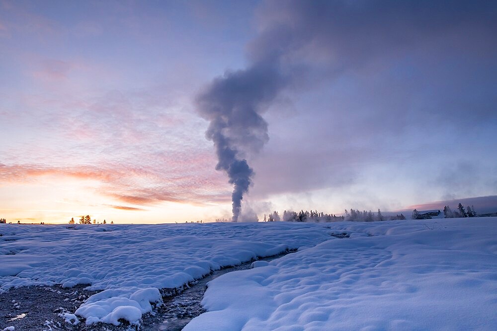 Sunrise eruption of Old Faithful geyser with stream, Yellowstone National Park, UNESCO World Heritage Site, Wyoming, United States of America, North America