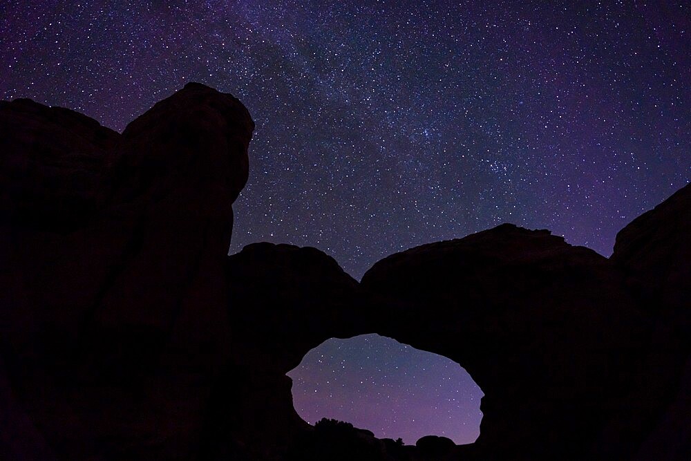 Starry sky viewed through Broken Arch, Arches National Park, Utah, United States of America, North America