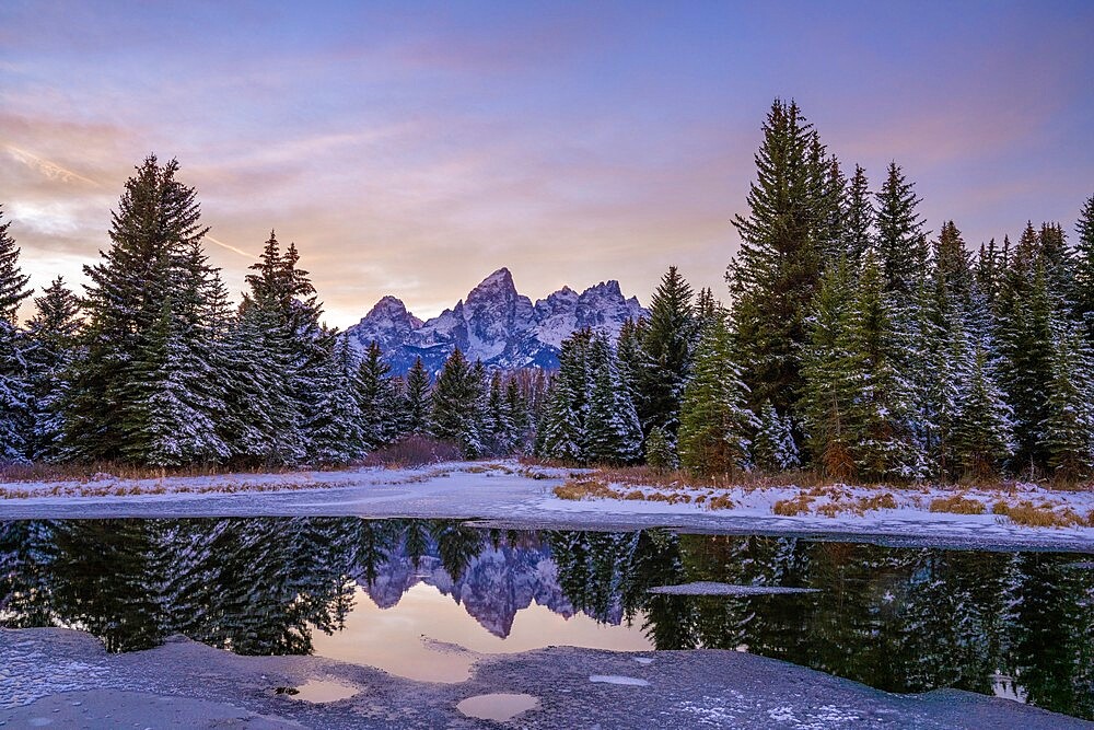 Evening light and reflection of Teton Range in snowy pond, Grand Teton National Park, Wyoming, United States of America, North America