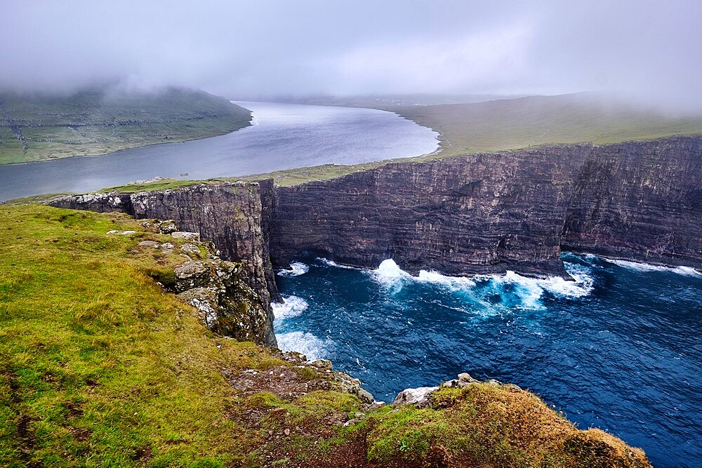 Cliffs of Traelanipa with the lake above the ocean, Faroe Islands, Denmark, Europe