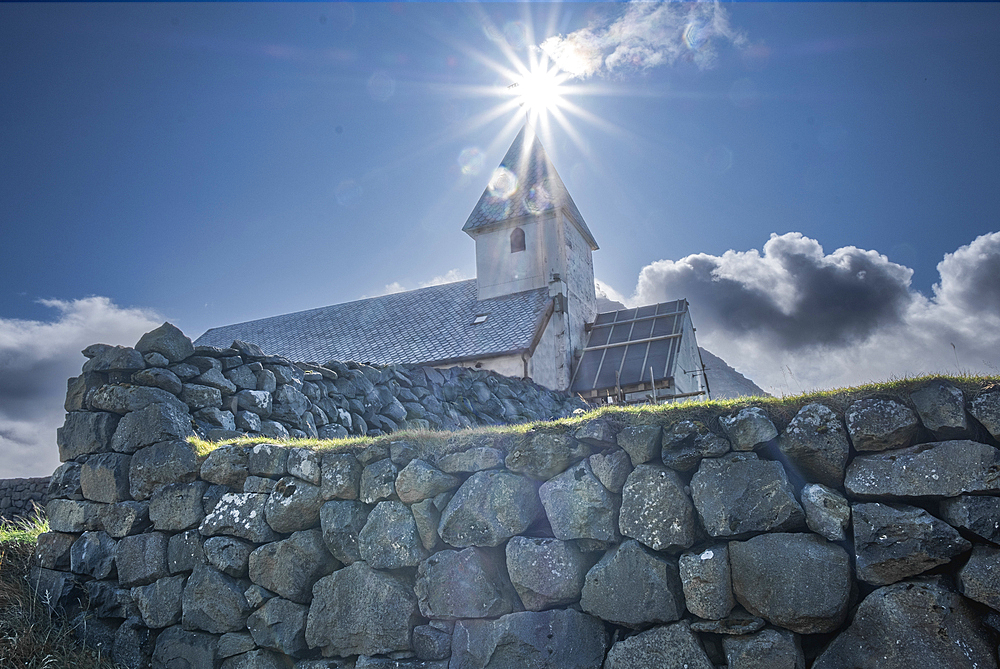 Vioareioi Church and the sun aligned with bell tower, Faroe Islands, Denmark, North Atlantic, Europe