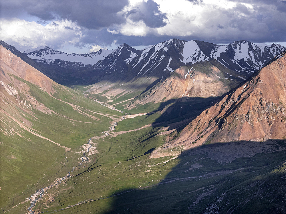 Snow-capped peaks and lush valleys at sunset showcased in a stunning landscape, Kyrgyzstan, Central Asia, Asia