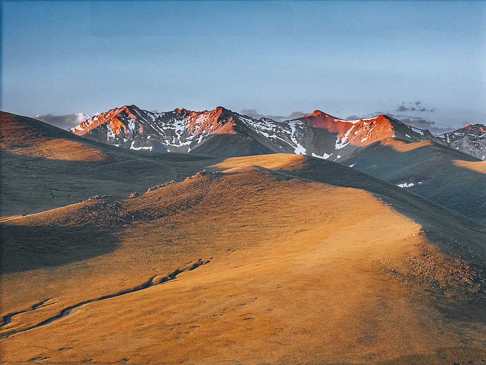 A view of the snow-capped mountains surrounding Song Kol Lake at sunrise, Kyrgyzstan