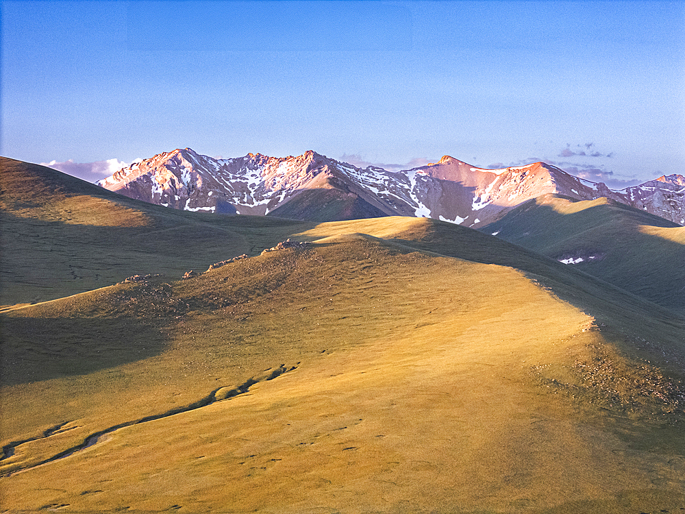 Vew of the Song Kol Lake area with yurts in foothills at sunrise, Kyrgyzstan