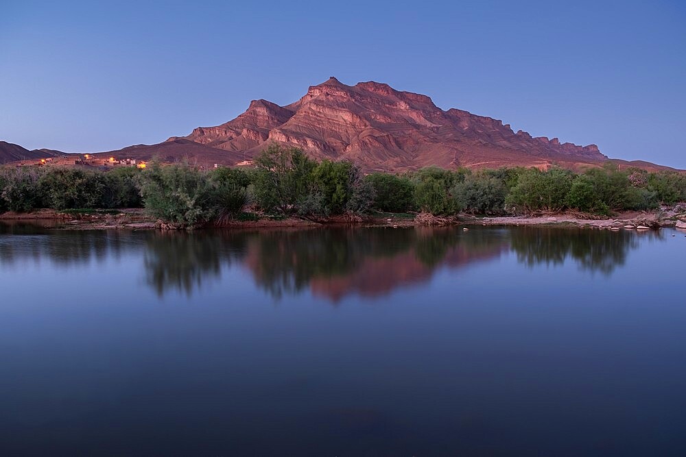 Blue hour in an oasis in the Draa Valley with a calm pond and a mountain in the background, Draa Valley, Morocco, North Africa, Africa