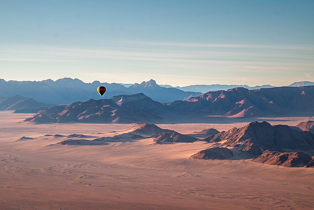 Rocky mountains, aerial view with hot air balloon flying over it, Namibia, Africa