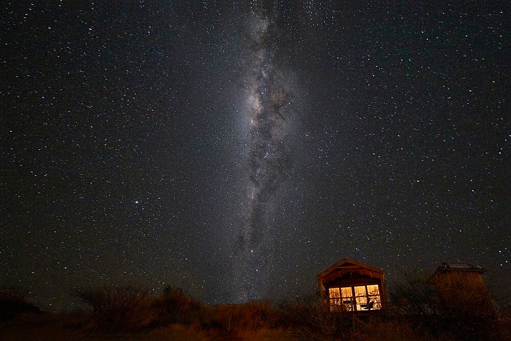 South hemisphere Milky Way and a small illuminated hut, Namibia, Africa