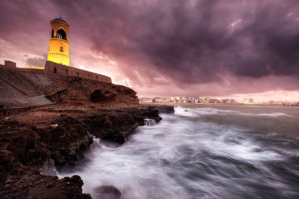 Sur lighthouse with the stormy sea on the cliff and a pink sunset, Sur, Oman, Middle East