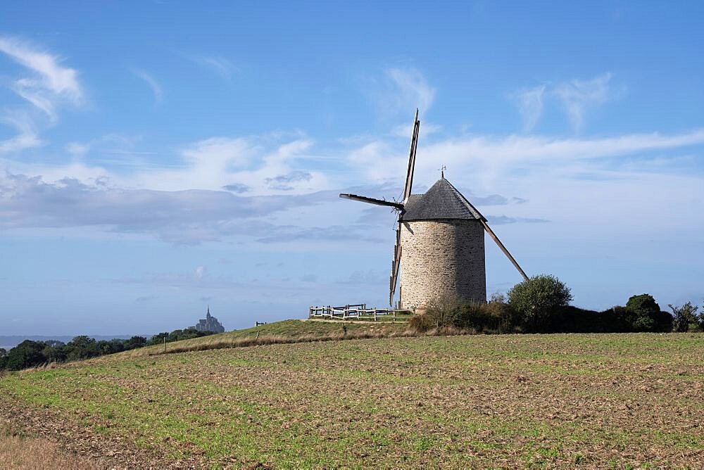 Wind mill on a top of a hill with Mont Saint Michel in the backround