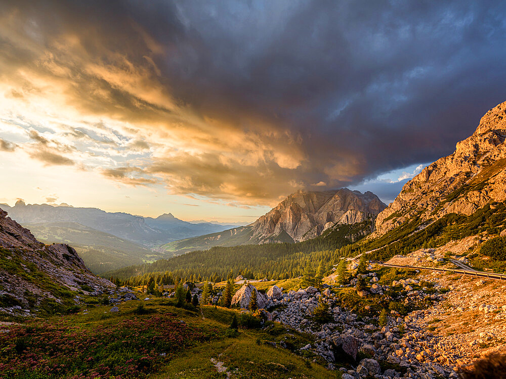 Sunset over Conturines mountain with colored clouds in the sky and golden light on the pine trees and in the valley, Dolomites, Italy, Europe