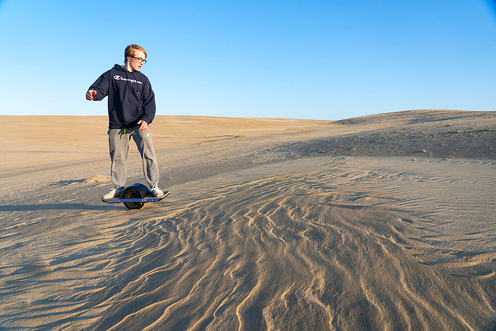 Christopher Brown rides his One-Wheel across a sand dune in Nags Head, North Carolina, United States of America, North America