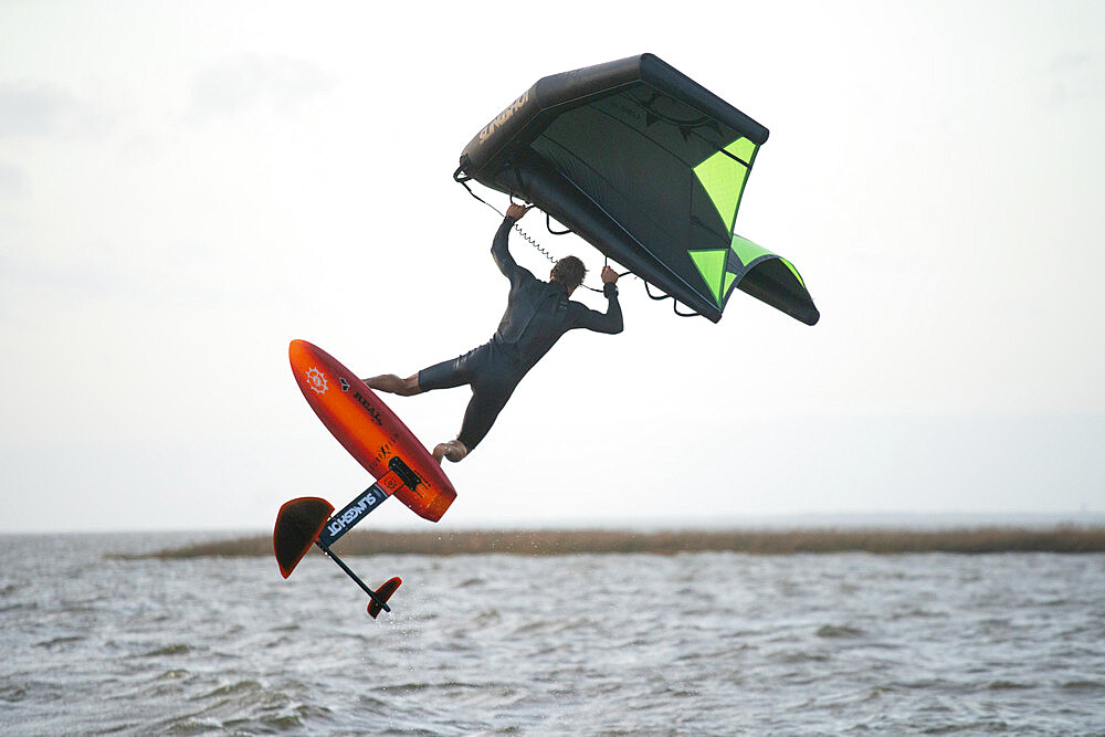 Pro surfer James Jenkins jumps his wing surfer over the Pamlico Sound at Nags Head, North Carolina, United States of America, North America