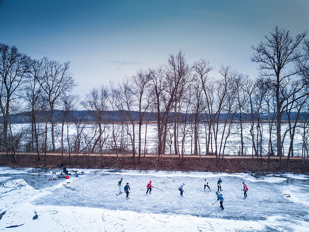 Ice skaters in a pond hockey game on the frozen C and O Canal (Chesapeake and Ohio Canal) next to the Potomac River, Maryland, United States of America, North America