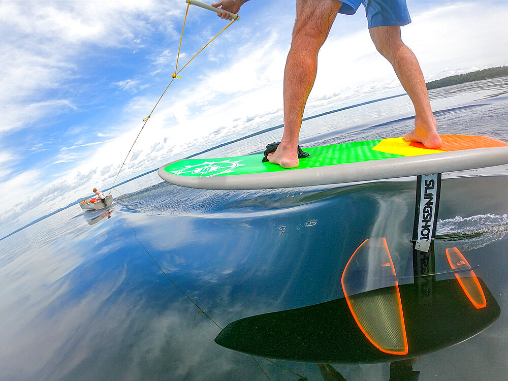 Photographer Skip Brown rides his hydrofoil behind a small boat at on Sebago Lake, Maine, United States of America, North America