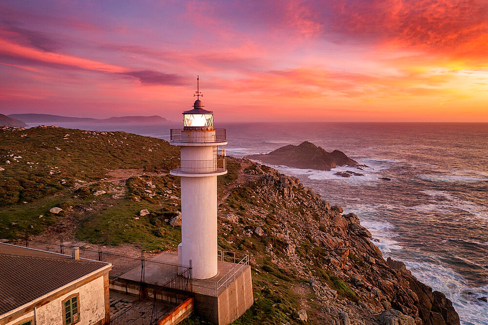 Aerial sea landscape view of Cape Tourinan Lighthouse at sunset with pink clouds, Galicia, Spain, Europe