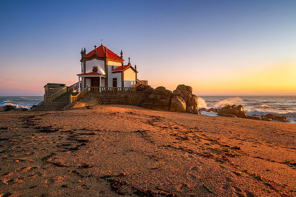 Beautiful chapel of Capela do Senhor da Pedra on the beach at sunset in Miramar, Vila Nova de Gaia, Portugal, Europe