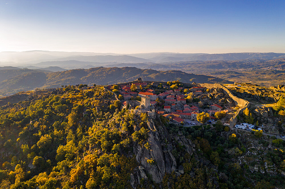 Drone aerial panorama of historic village of Sortelha with castle and with turbines on natural landscape, Centro, Portugal, Europe