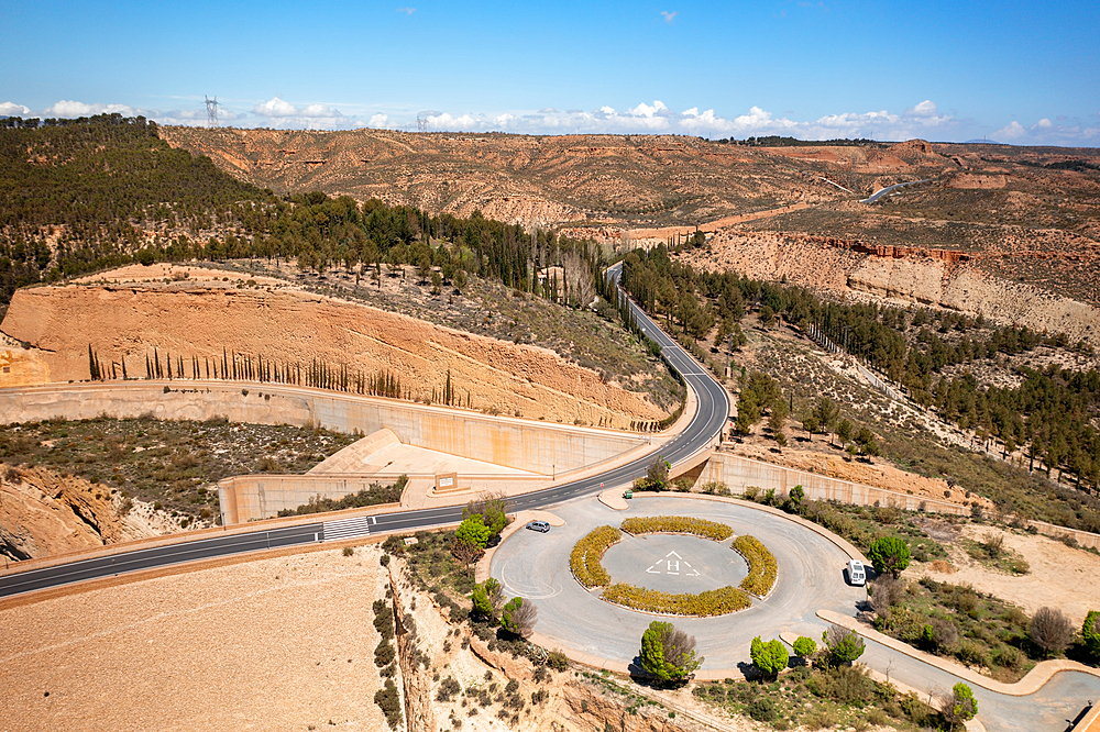 Drone aerial view of a helicopter landing parking on a desert like landscape near Francisco Abellan Dam and Reservoir, Granada, Andalusia, Spain, Europe