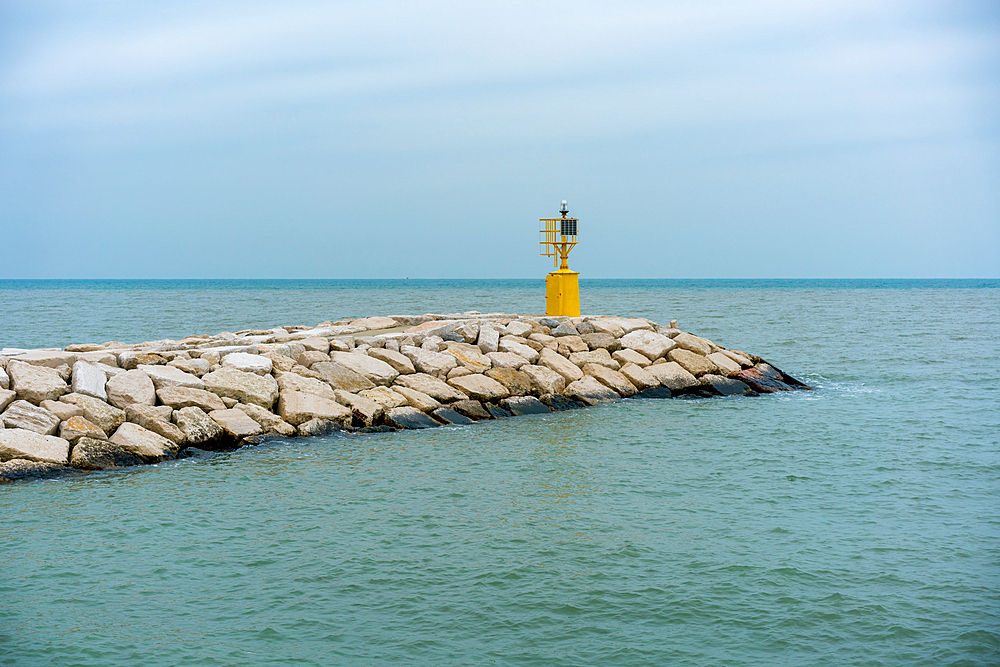 Yellow lighthouse on a cloudy day in Rimini, Emilia-Romagna, Italy, Europe