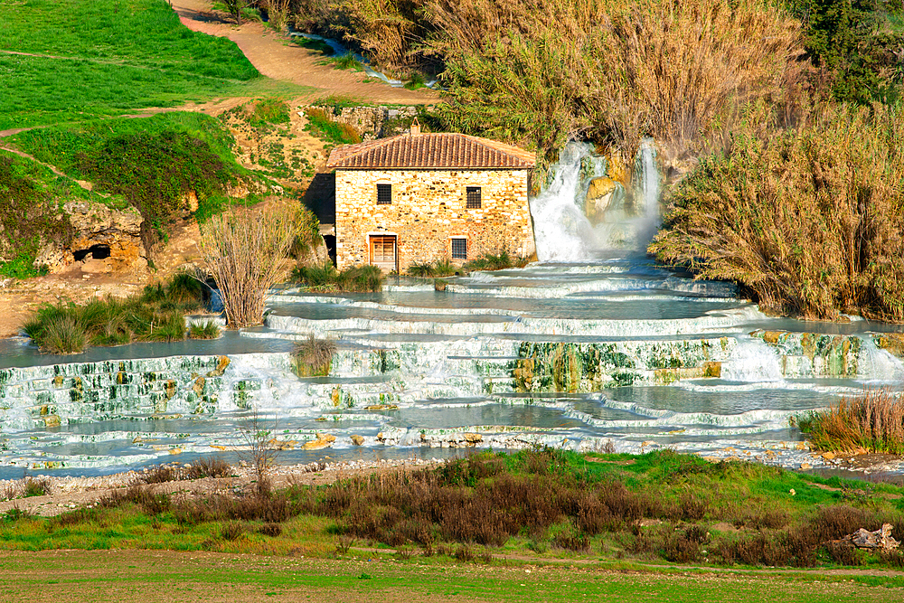 Saturnia hot springs with turquoise water and an old mill in Tuscany, Italy